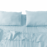 Light blue bedding set with pillows on a white background