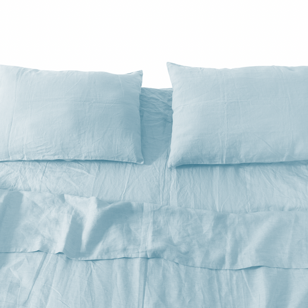 Light blue bedding set with pillows on a white background