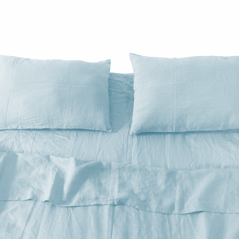 Light blue bedding set with pillows on a white background