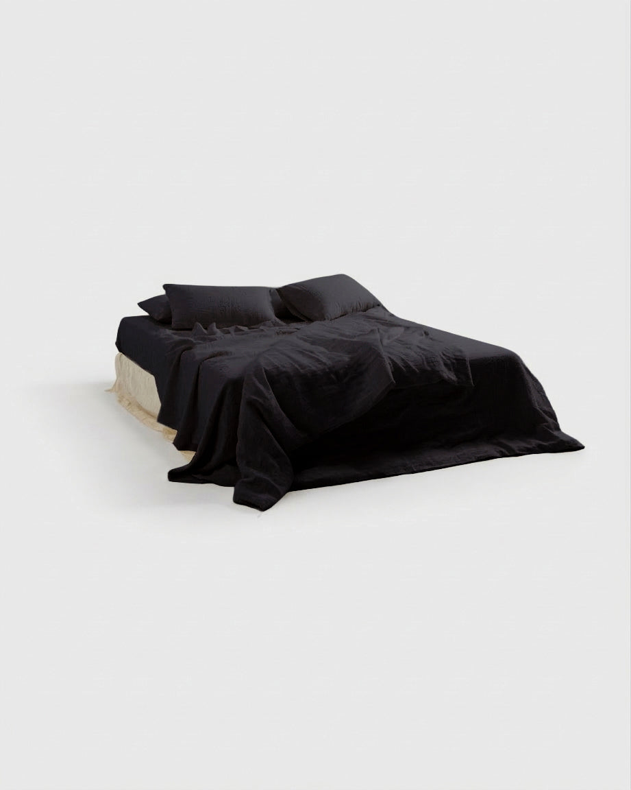 Black French linen duvet cover on a bed, side view