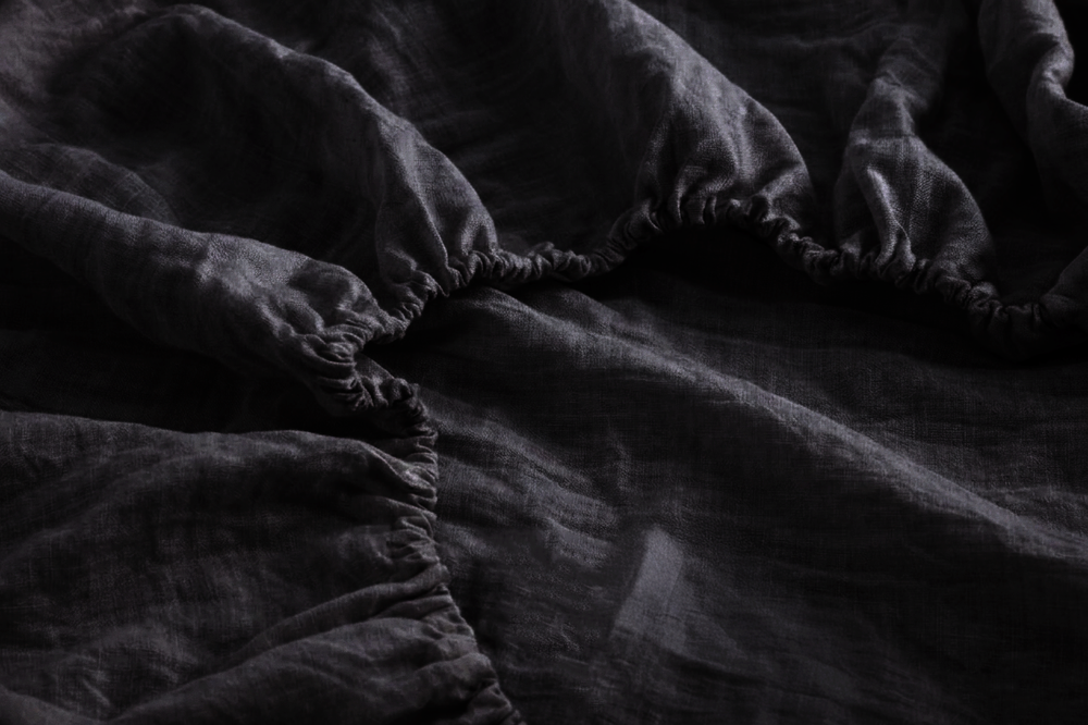 Black French linen fitted sheet elastic edge, close-up