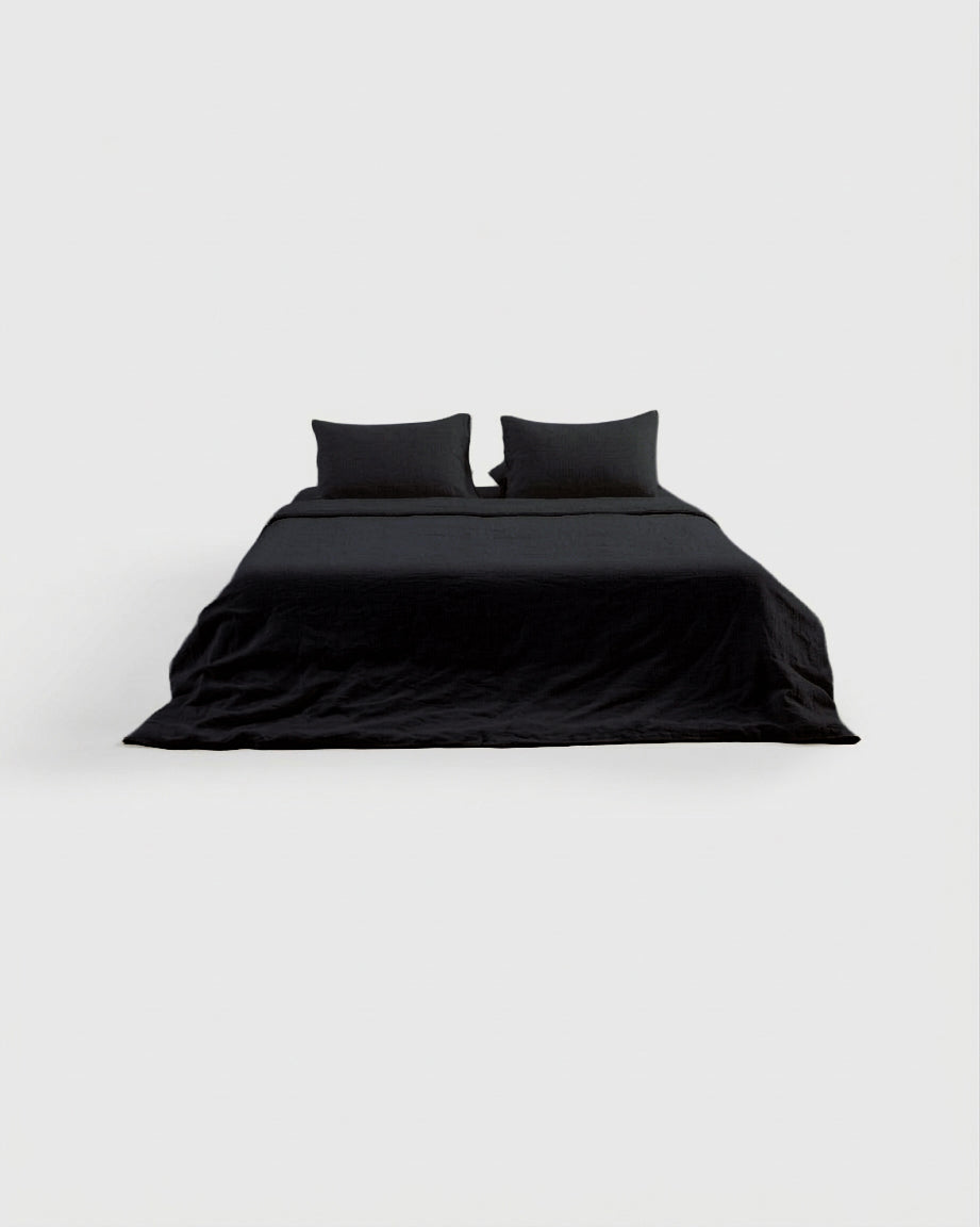 Black French linen sheet set on a bed, front view