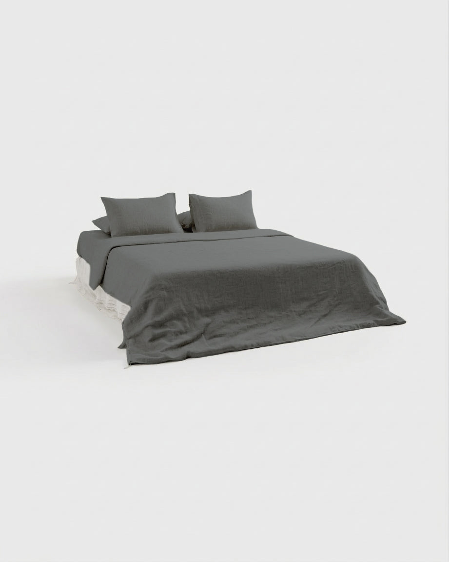 Smoke grey French linen bedding set on a bed, side view showing the fitted sheet