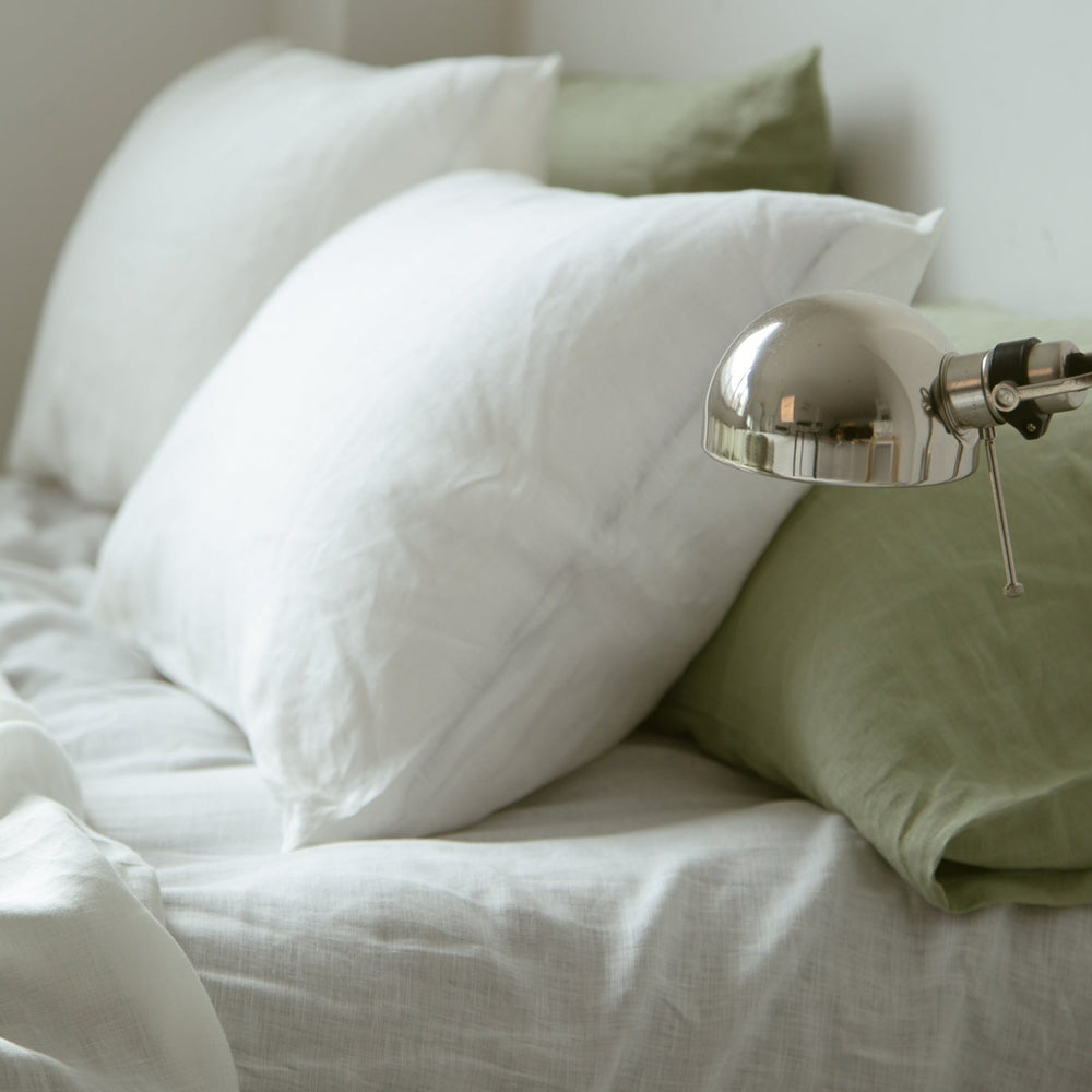 White French linen pillowcases with a sage pillowcase and a desk lamp