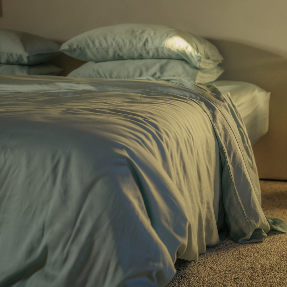 Mint green eucalyptus TENCEL duvet cover draped to the floor, close-up