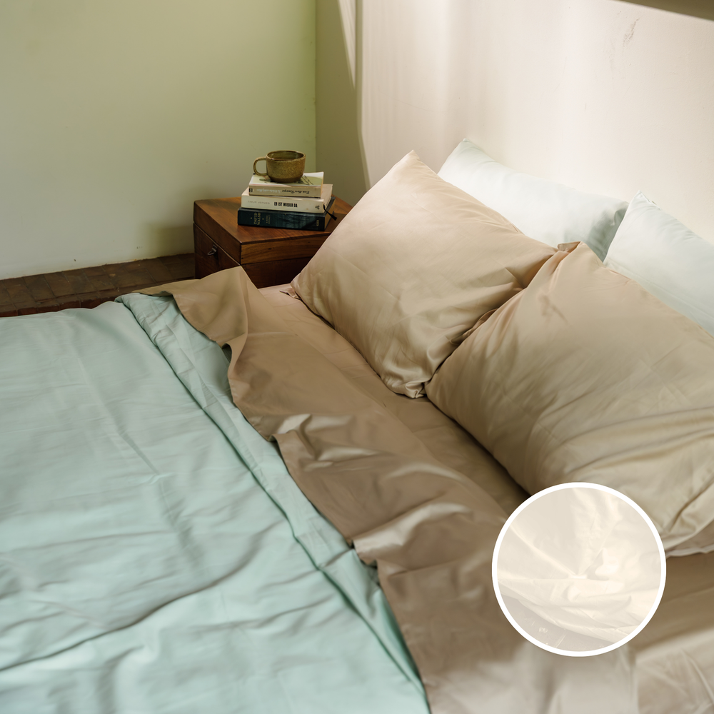 Organic cotton sateen sheets and pillowcases on a styled bed, with a close-up of the white fabric