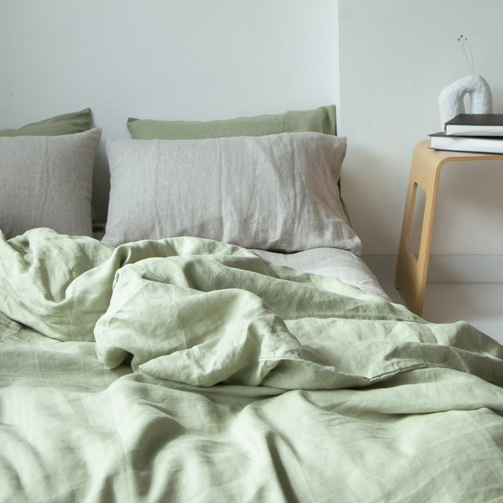 Sage green French linen duvet cover with pale grey pillowcases, softly rumpled